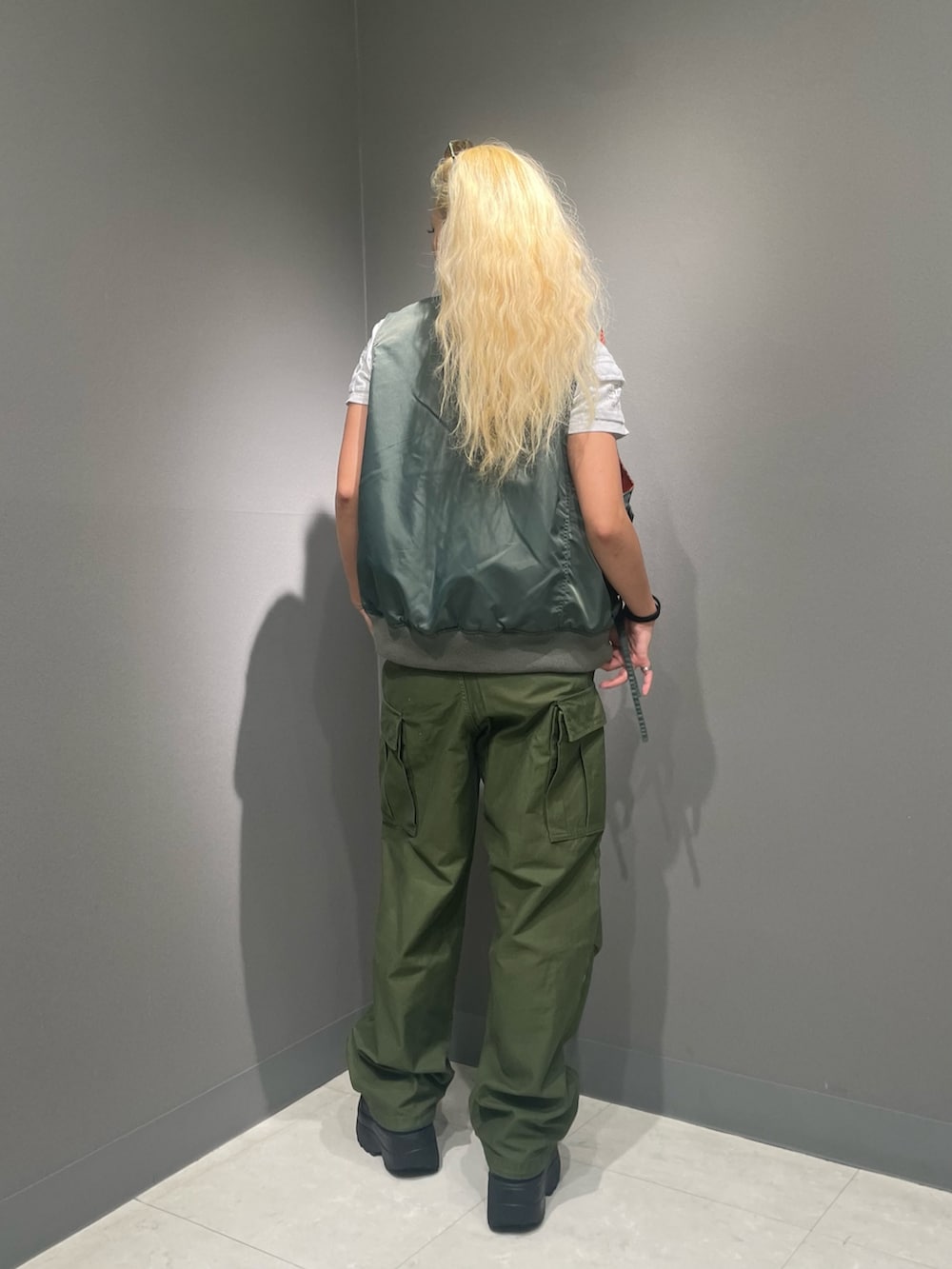 グリーン系のカーゴパンツ、ホワイト系のTシャツ/カットソー、グリーン系のナイロンジャケットを着用したレディースの夏コーディネートの2枚目の写真