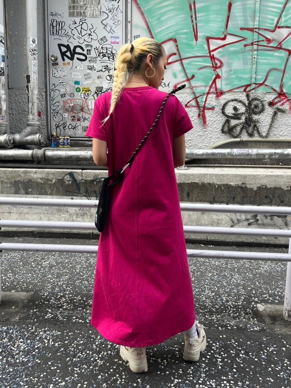 ブラック系のショルダーバッグ、ピンク系のワンピースを着用したレディースの春コーディネートの2枚目の写真