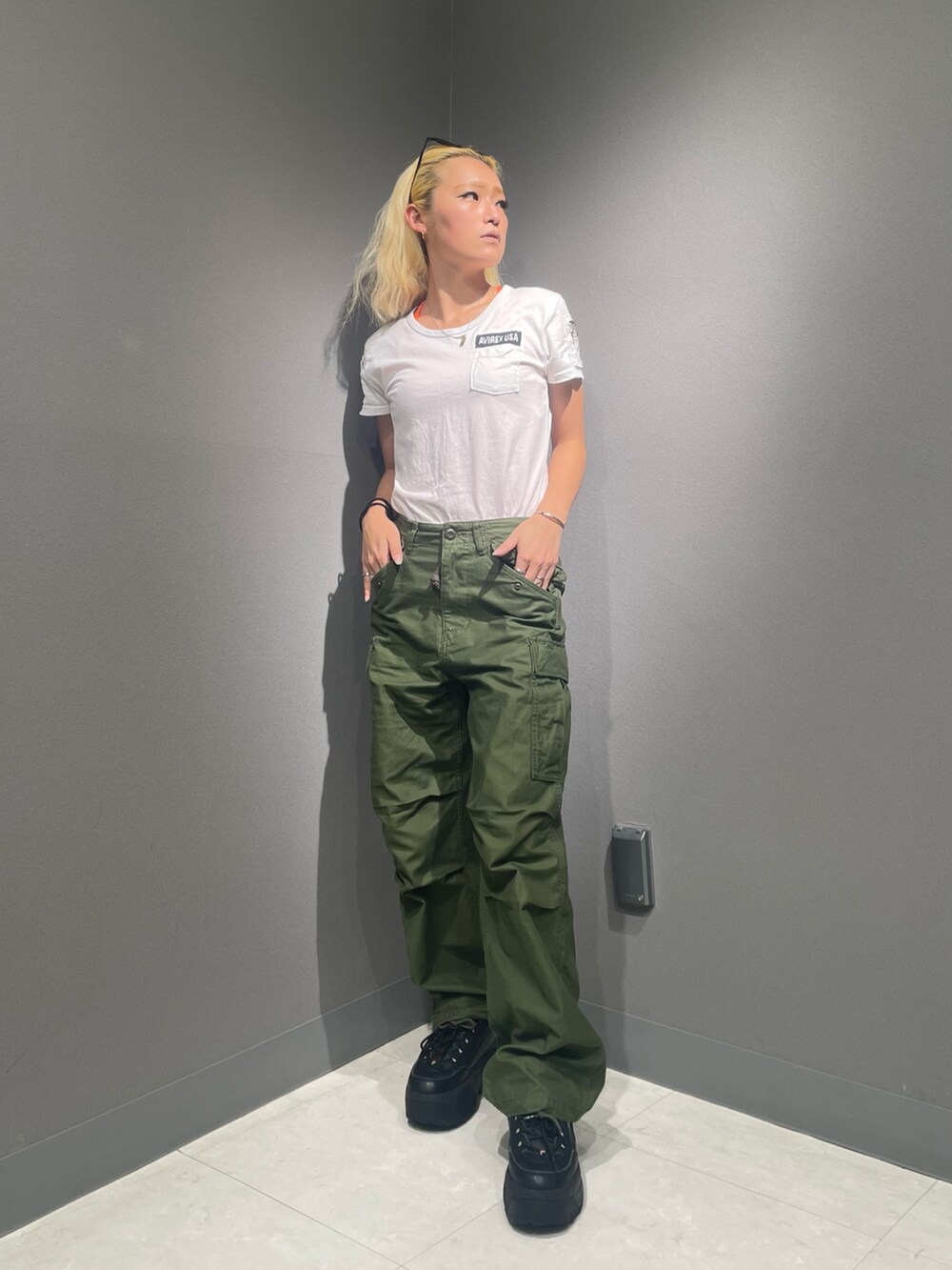 グリーン系のカーゴパンツ、ホワイト系のTシャツ/カットソー、グリーン系のサングラスを着用したレディースの夏コーディネートの2枚目の写真