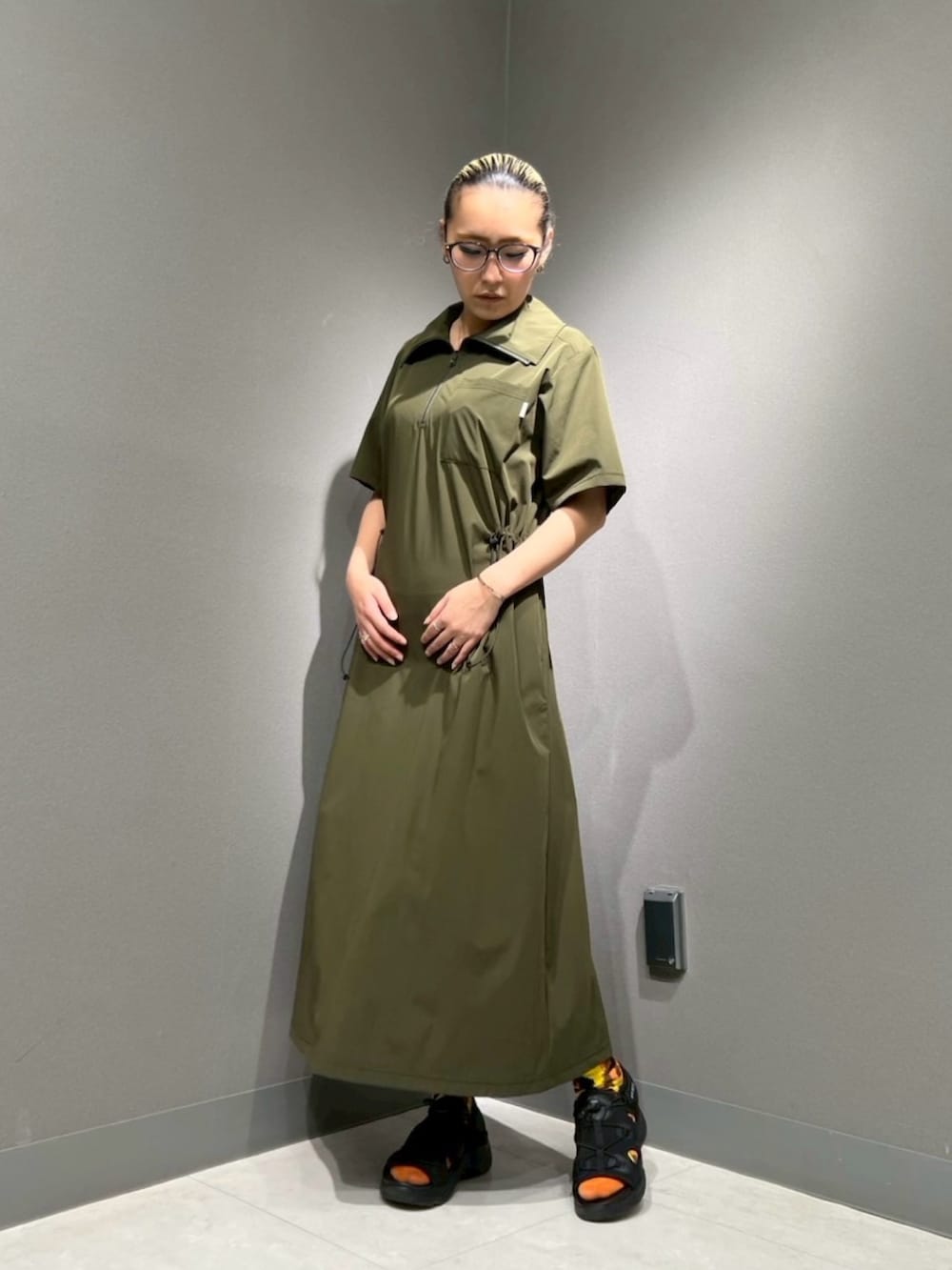 ブラック系のサンダル、グリーン系のワンピースを着用したレディースの春コーディネートの2枚目の写真