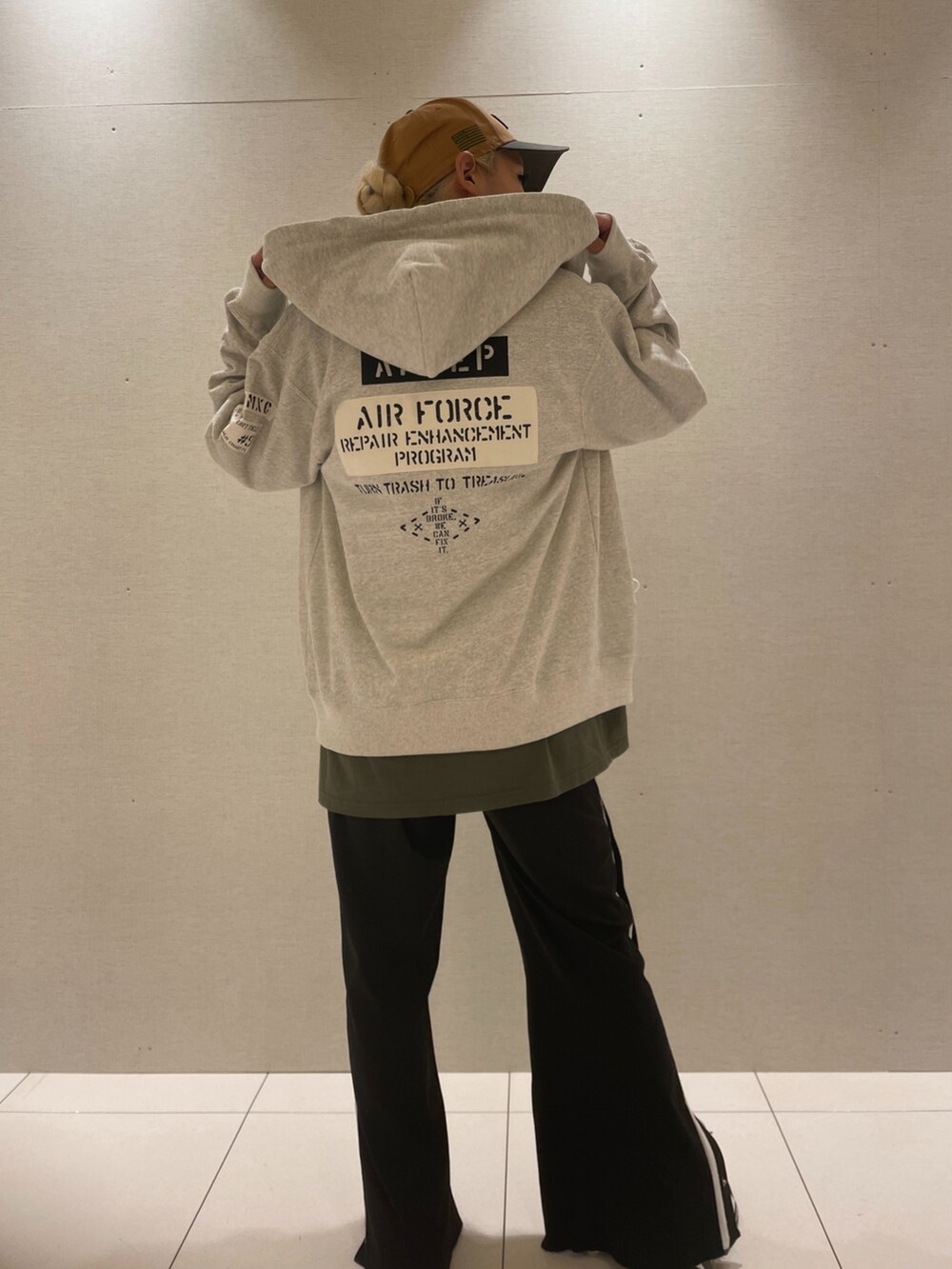 グリーン系のTシャツ/カットソー、グレー系のパーカー、グリーン系のキャップを着用したレディースの秋コーディネートの2枚目の写真