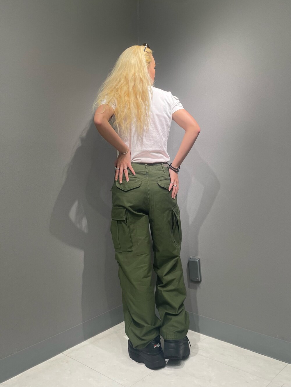 グリーン系のカーゴパンツ、ホワイト系のTシャツ/カットソー、グリーン系のサングラスを着用したレディースの夏コーディネートの3枚目の写真