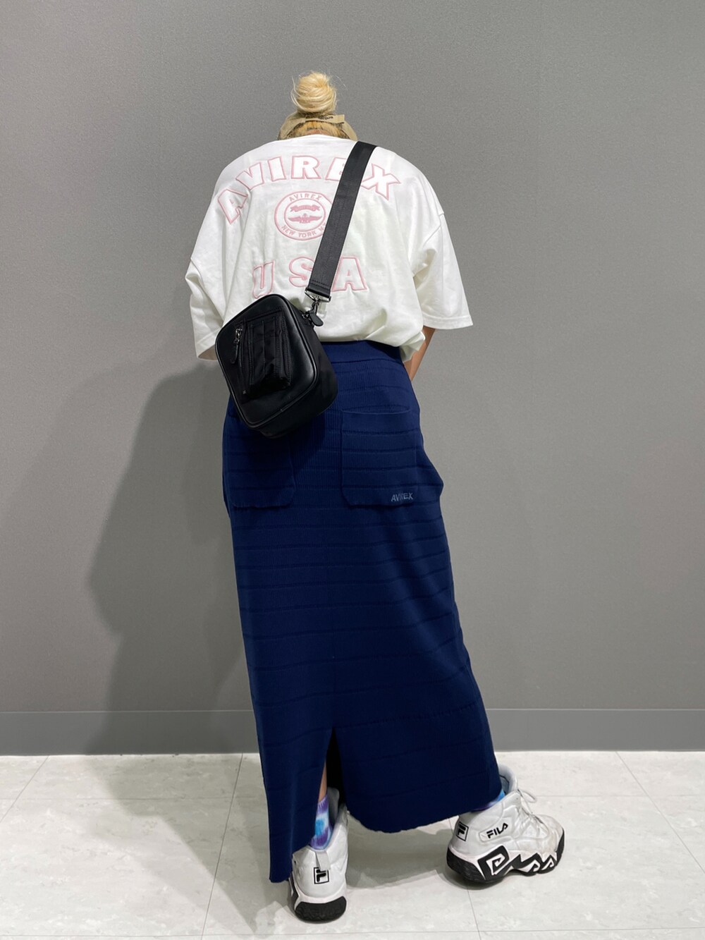 ブルー系のスカート、ホワイト系のTシャツ/カットソー、ブラック系のショルダーバッグを着用したレディースの夏コーディネートの2枚目の写真