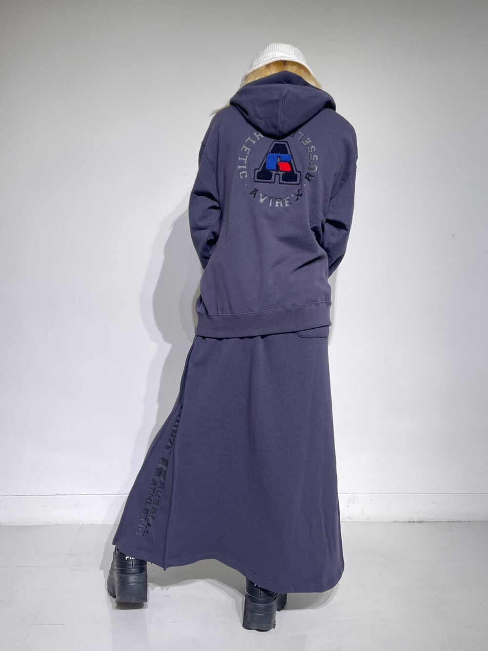 ブラック系のスカート、ブラック系のパーカー、ブラック系のトートバッグを着用したレディースの秋コーディネートの2枚目の写真