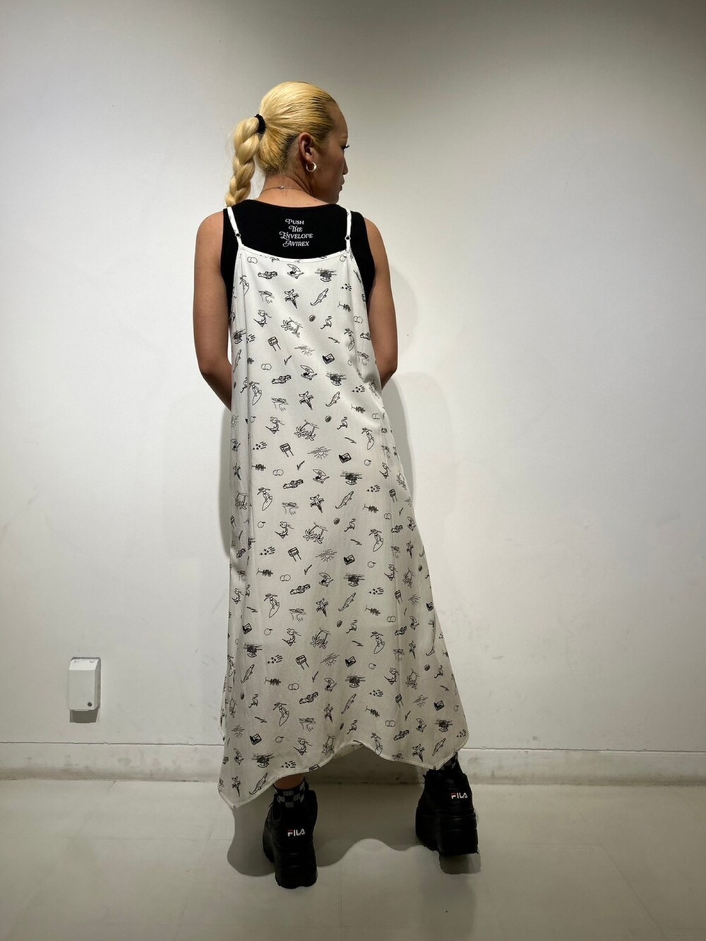 ホワイト系のワンピース、ブラック系のタンクトップを着用したレディースの夏コーディネートの2枚目の写真