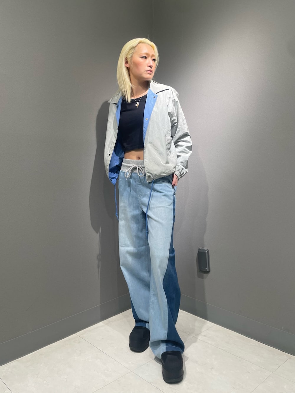 ブルー系のデニムパンツ、ホワイト系のTシャツ/カットソー、ブルー系のナイロンジャケットを着用したレディースの冬コーディネートの2枚目の写真