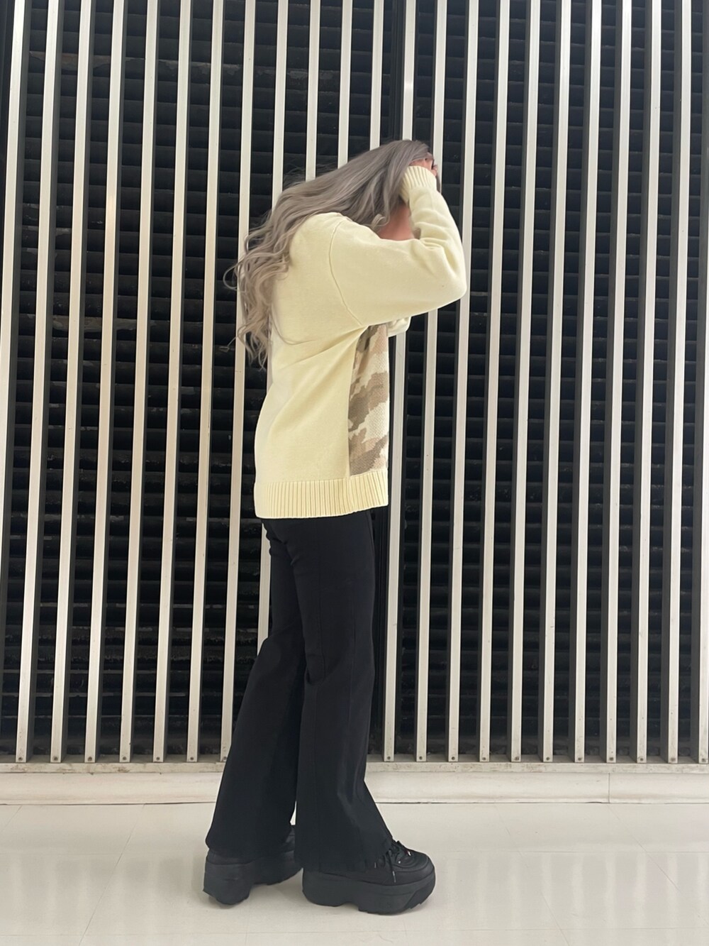 ブラック系のチノパンツ、ホワイト系のニット/セーターを着用したレディースの冬コーディネートの2枚目の写真