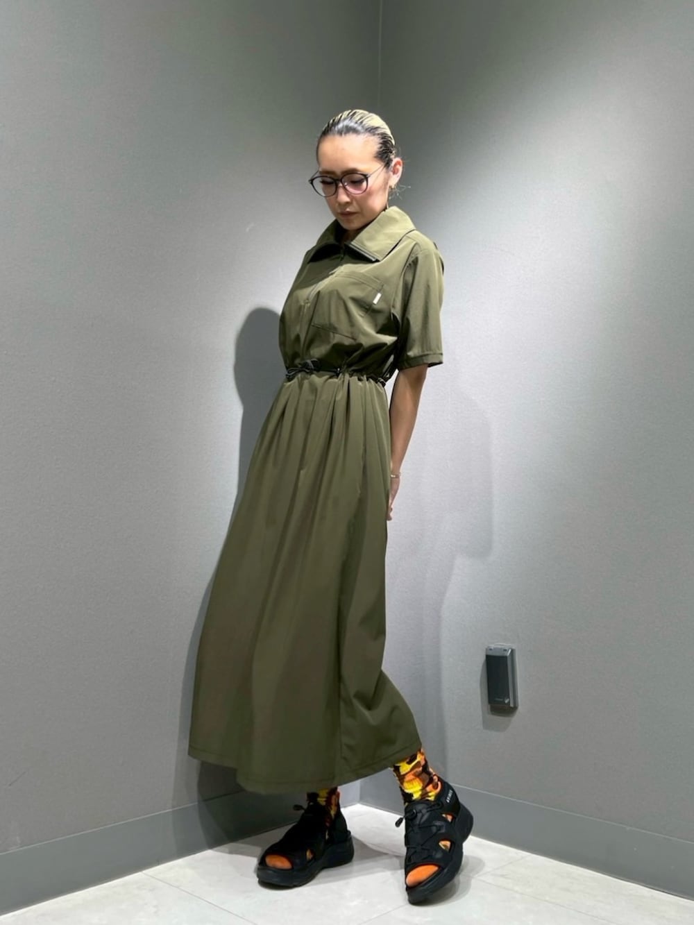 ブラック系のサンダル、グリーン系のワンピースを着用したレディースの春コーディネートの3枚目の写真