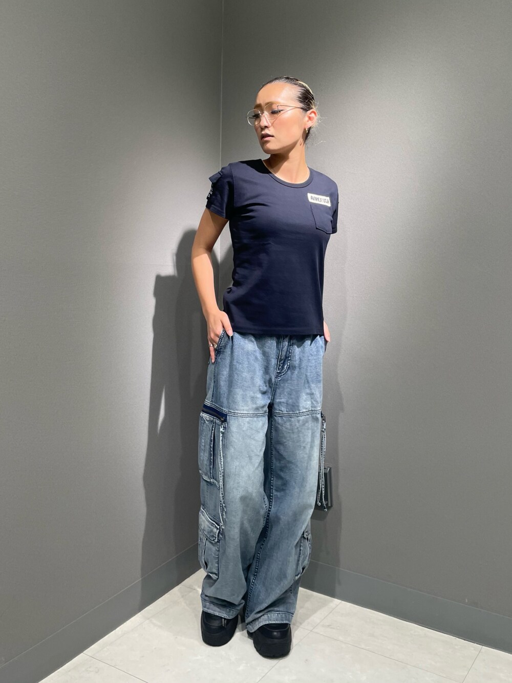 ブルー系のデニムパンツ、ブルー系のTシャツ/カットソー、ブラック系のソックス/靴下を着用したレディースの夏コーディネートの2枚目の写真