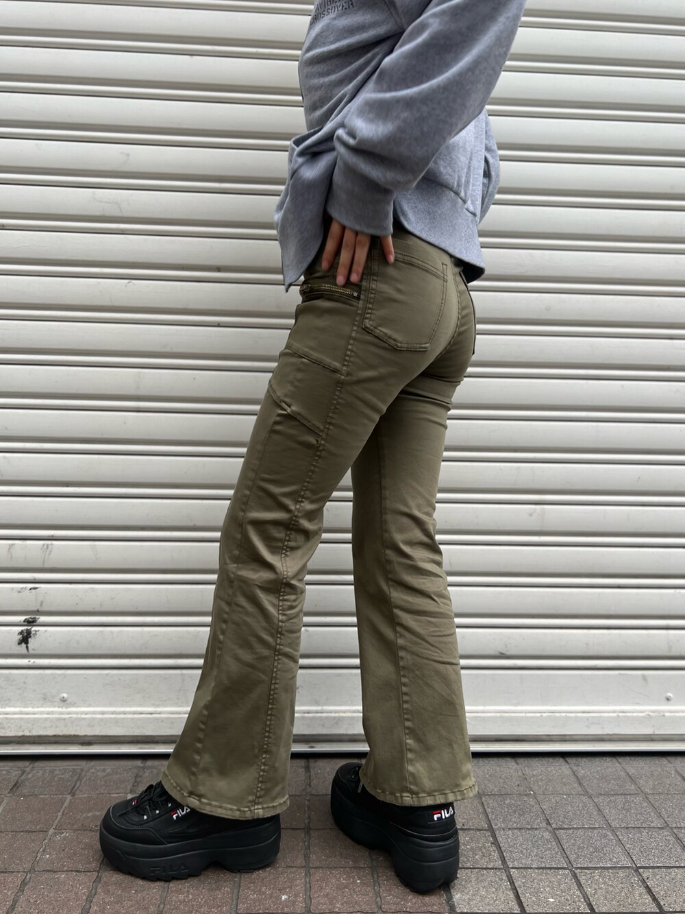 グリーン系のチノパンツ、グレー系のパーカーを着用したレディースの秋コーディネートの2枚目の写真