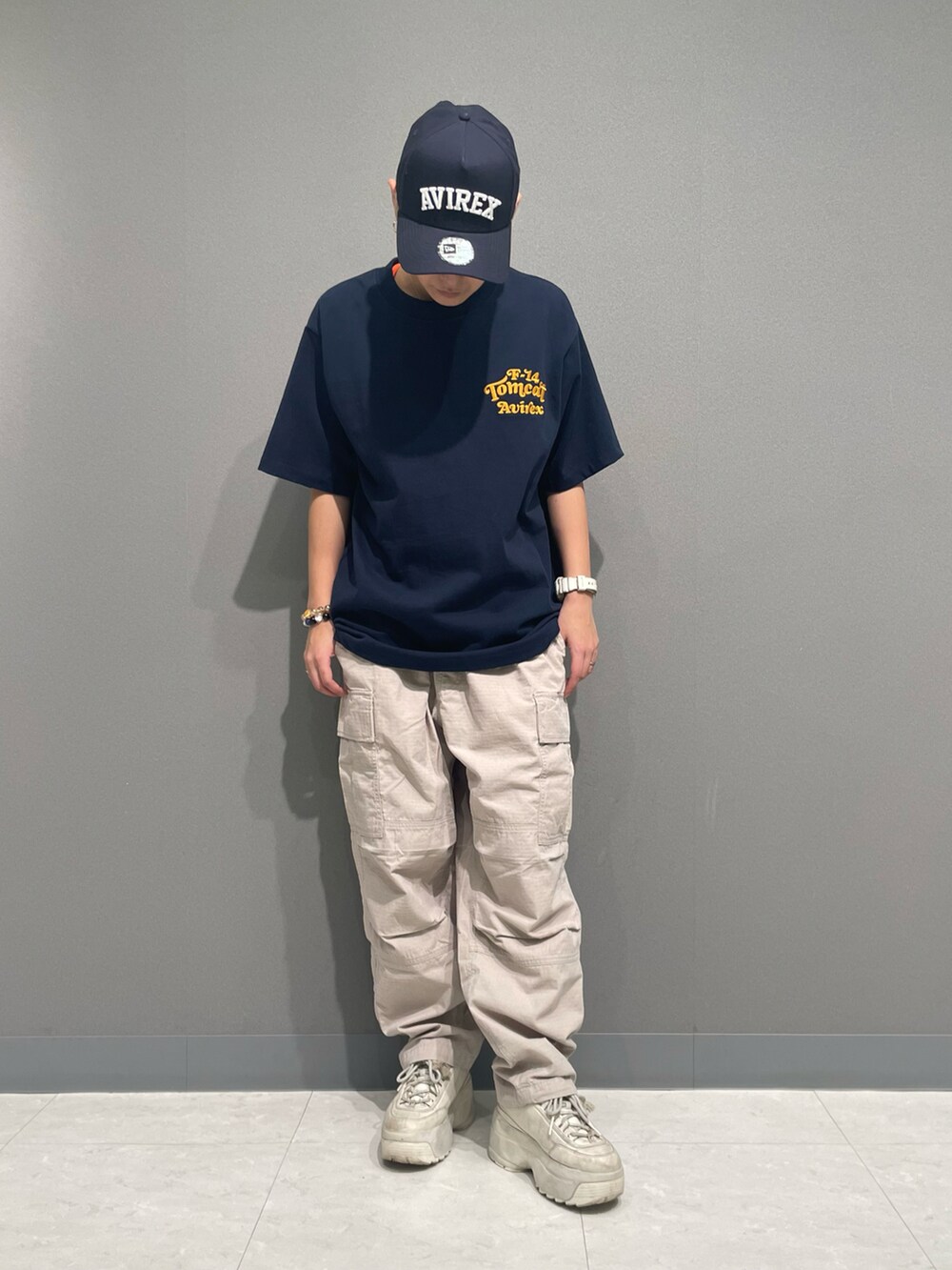 グレー系のカーゴパンツ、ブルー系のTシャツ/カットソー、ブラック系のキャップを着用したレディースの春コーディネートの2枚目の写真