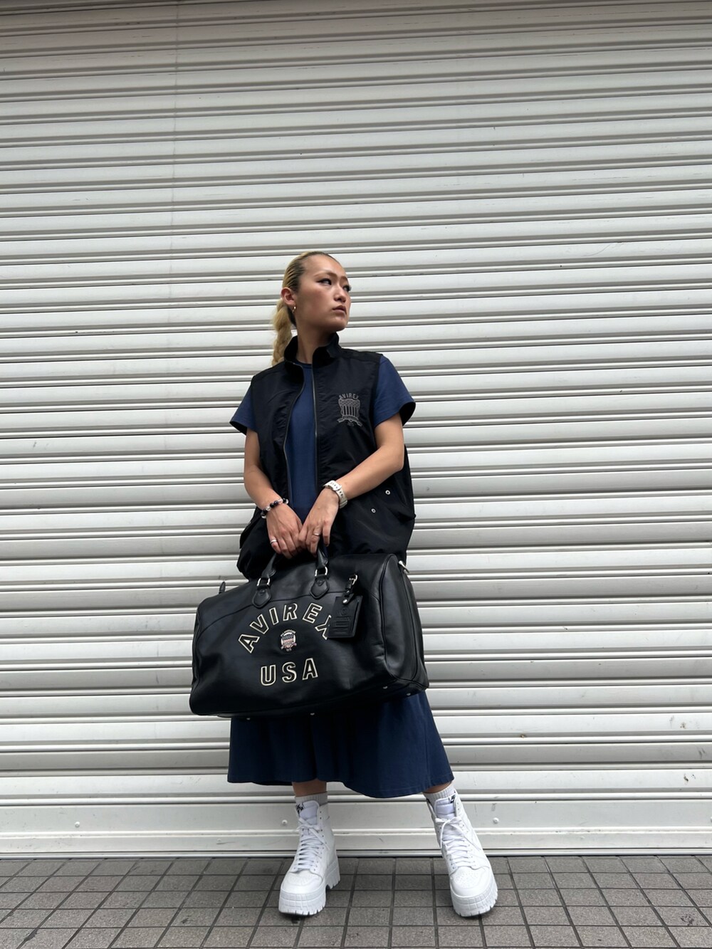 ピンク系のワンピース、ブラック系のベスト、ブラック系のボストンバッグを着用したレディースの夏コーディネートの2枚目の写真