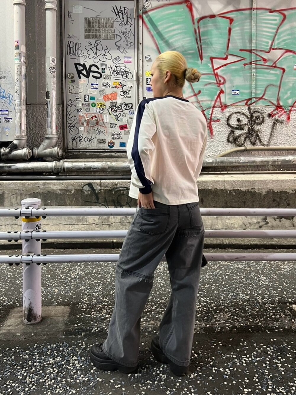 ブラック系のデニムパンツ、ホワイト系のTシャツ/カットソー、ブラック系のブルゾンを着用したレディースの冬コーディネートの2枚目の写真