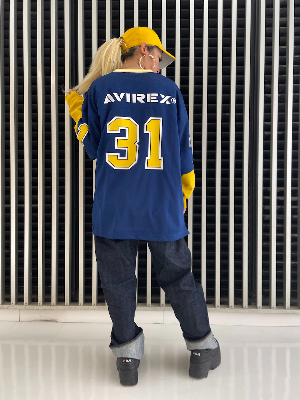 イエロー系のスウェット、ブルー系のTシャツ/カットソー、ブルー系のデニムパンツを着用したレディースの冬コーディネートの2枚目の写真