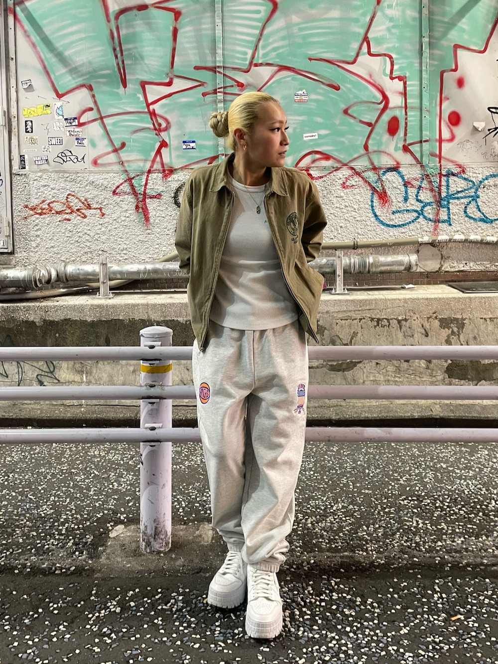 ブラック系のブルゾン、パープル系のスウェットパンツを着用したレディースの冬コーディネートの2枚目の写真