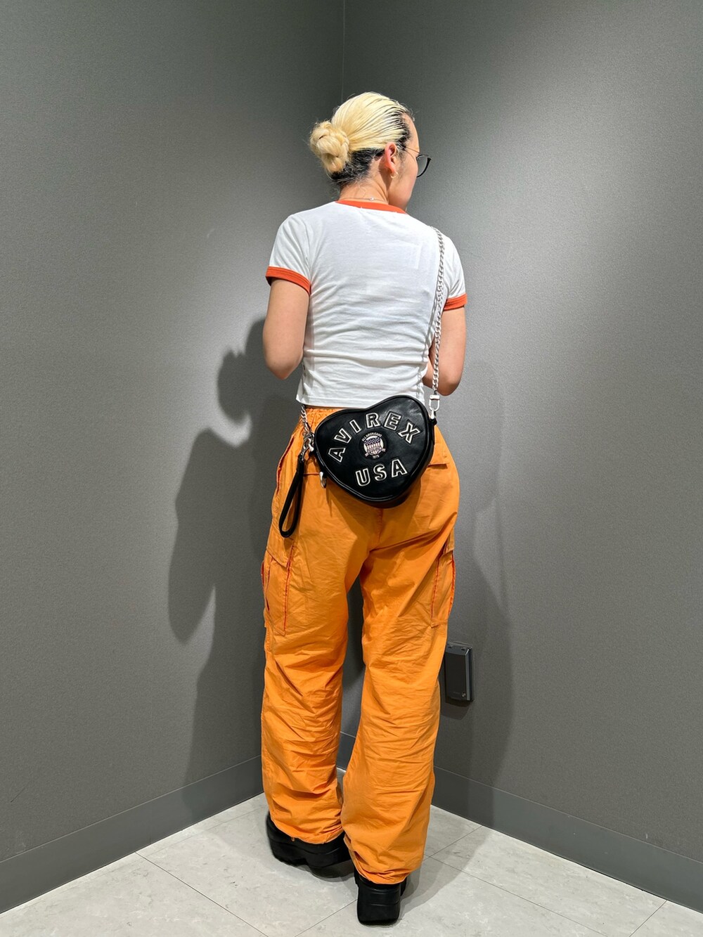 ホワイト系のTシャツ/カットソー、オレンジ系のカーゴパンツ、ブラック系のショルダーバッグを着用したレディースの春コーディネートの3枚目の写真