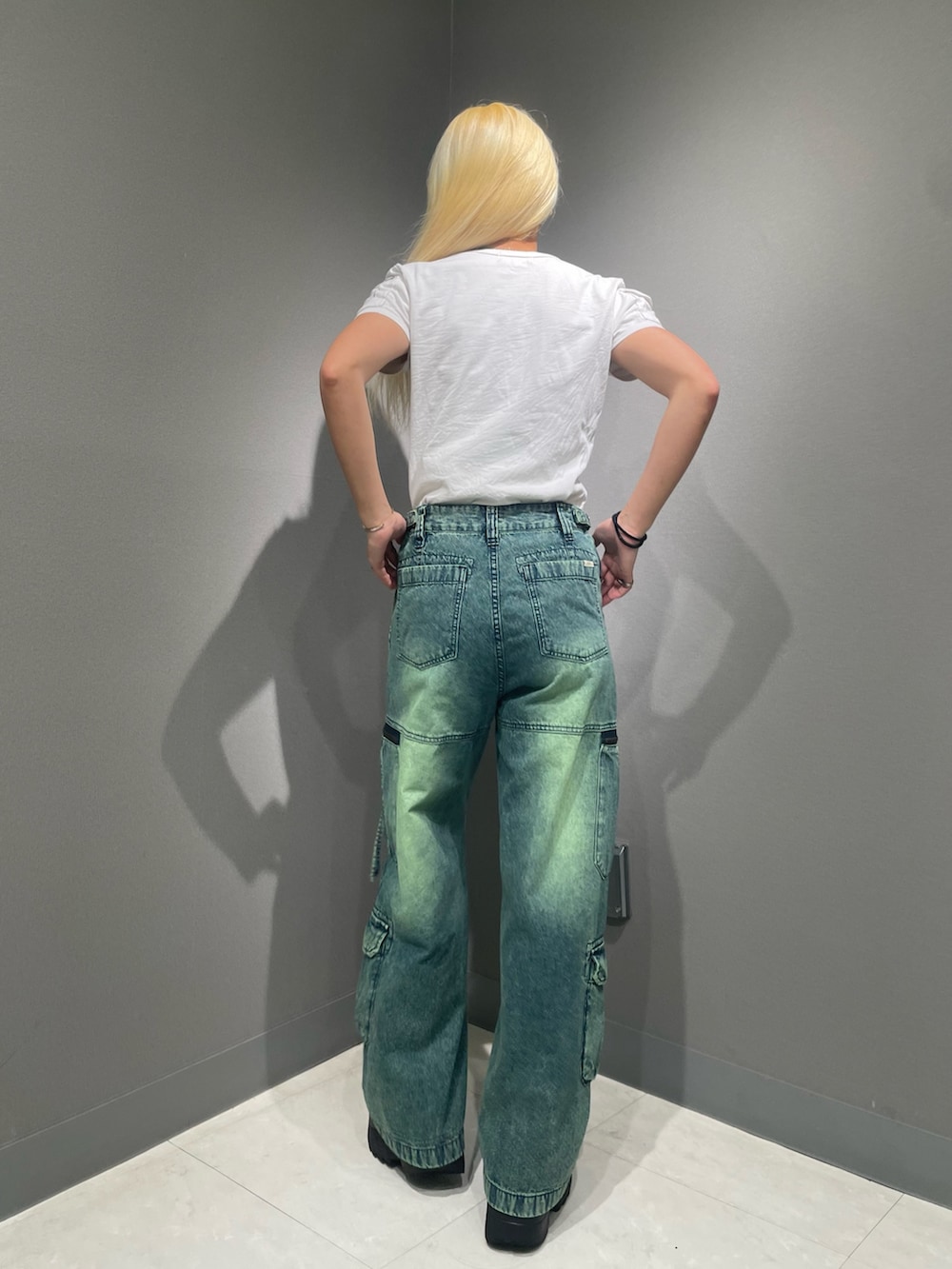 グリーン系のデニムパンツ、ホワイト系のTシャツ/カットソーを着用したレディースの夏コーディネートの2枚目の写真