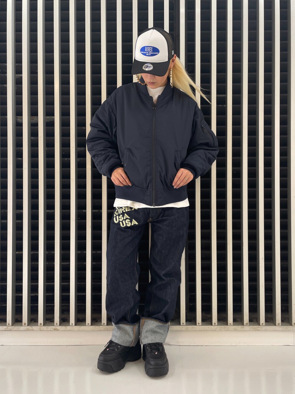 ブルー系のデニムパンツ、ベージュ系のキャップを着用したレディースの夏コーディネートの2枚目の写真