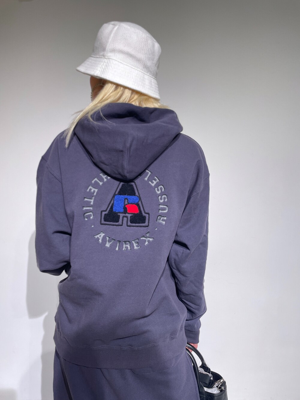 ブラック系のスカート、ブラック系のパーカー、ブラック系のトートバッグを着用したレディースの秋コーディネートの4枚目の写真