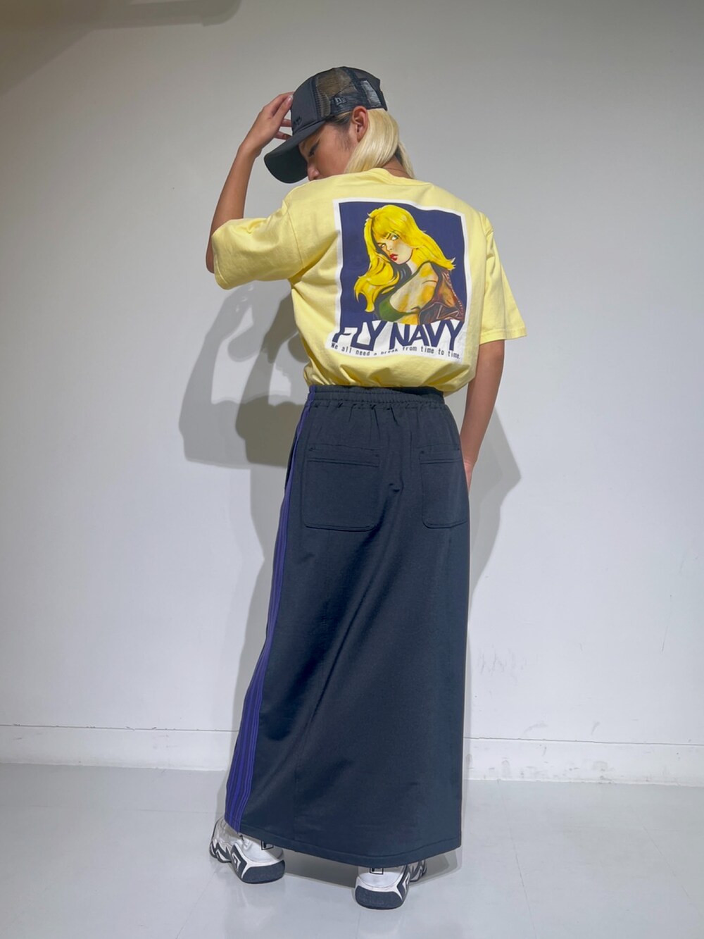 ベージュ系のTシャツ/カットソー、ブラック系のスカート、ブラック系のキャップを着用したレディースの夏コーディネートの2枚目の写真