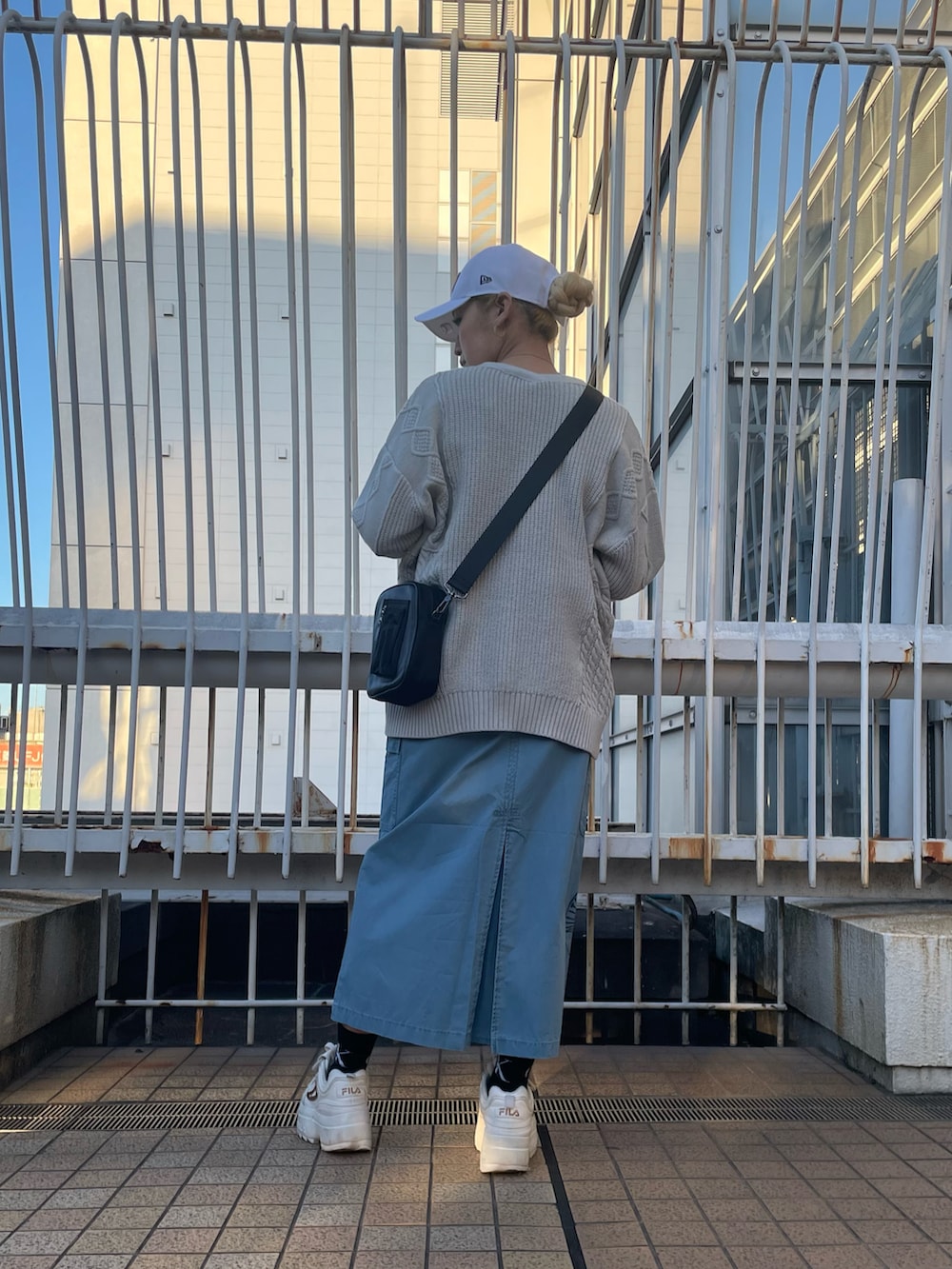 ブルー系のジャンパースカート、グレー系のカーディガン/ボレロ、ホワイト系のTシャツ/カットソーを着用したレディースの冬コーディネートの2枚目の写真