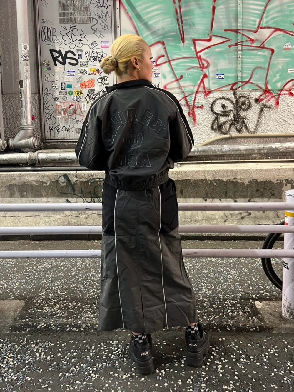 グレー系のスカート、グレー系のナイロンジャケットを着用したレディースの冬コーディネートの2枚目の写真