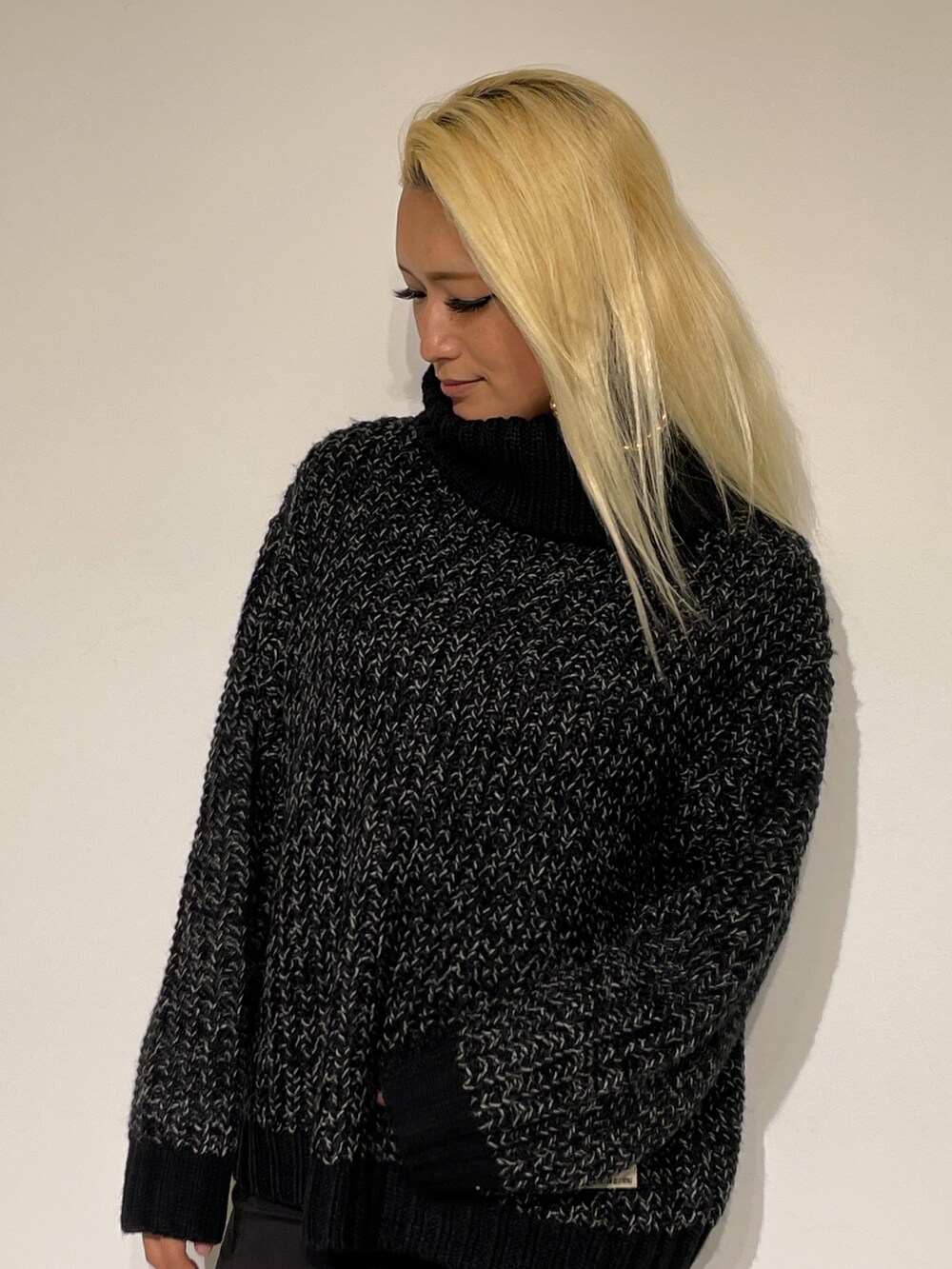 ブラック系のブーツ、グリーン系のその他パンツ、ブラック系のニット/セーターを着用したレディースの秋コーディネートの2枚目の写真