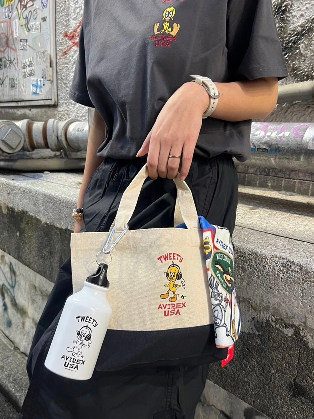 ブラック系のスカート、ホワイト系のトートバッグ、ブラック系のTシャツ/カットソーを着用したレディースの春コーディネートの2枚目の写真