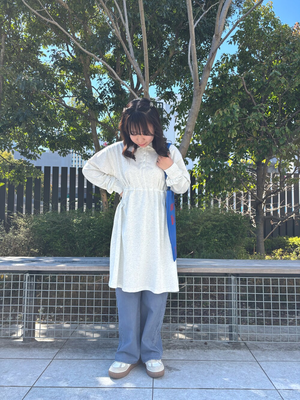 ホワイト系のハンドバッグ、ホワイト系のワンピース、ブルー系のその他パンツを着用したレディースの春コーディネートの2枚目の写真