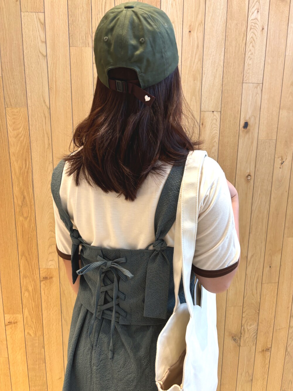 ホワイト系のハンドバッグ、ブラック系のワンピース/ドレス、イエロー系のスニーカーを着用したレディースの夏コーディネートの2枚目の写真