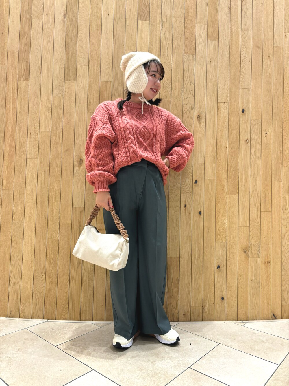 ベージュ系のハンドバッグ、グリーン系のその他パンツ、ホワイト系のハットを着用したレディースの冬コーディネートの2枚目の写真