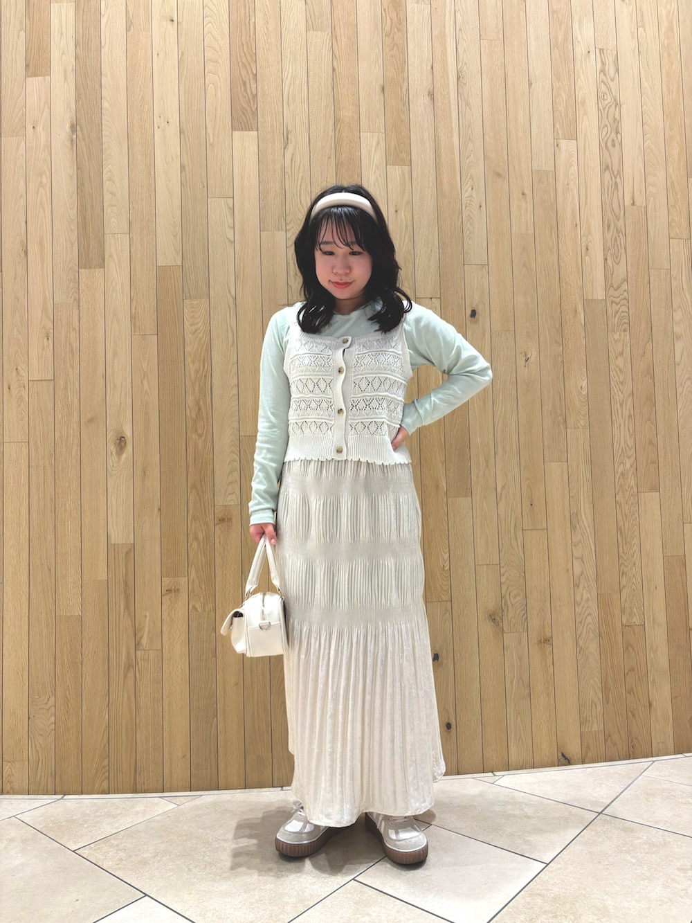 グレー系のノーカラージャケット、ホワイト系のニット/セーター、グリーン系のTシャツ/カットソーを着用したレディースの春コーディネートの2枚目の写真