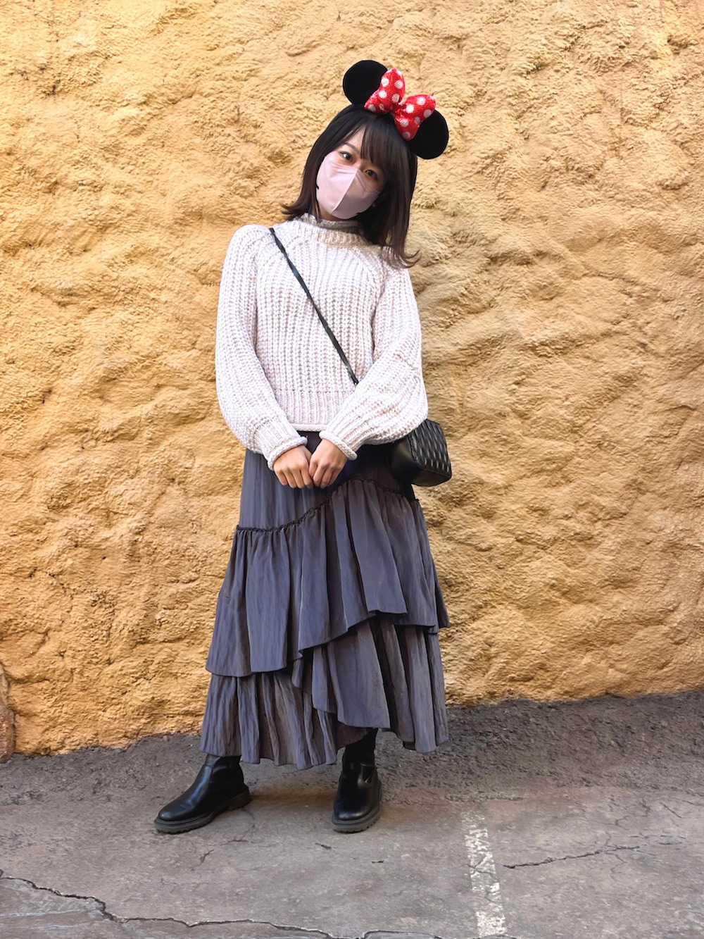 ブラック系のその他アウター、ブラック系のブーツ、ブラック系のショルダーバッグを着用したレディースの冬コーディネートの2枚目の写真