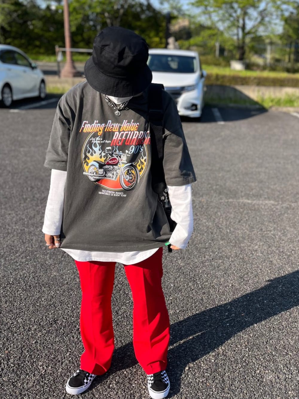 ブラック系のTシャツ/カットソー、ホワイト系のTシャツ/カットソー、レッド系のスラックスを着用したレディースの春コーディネートの2枚目の写真