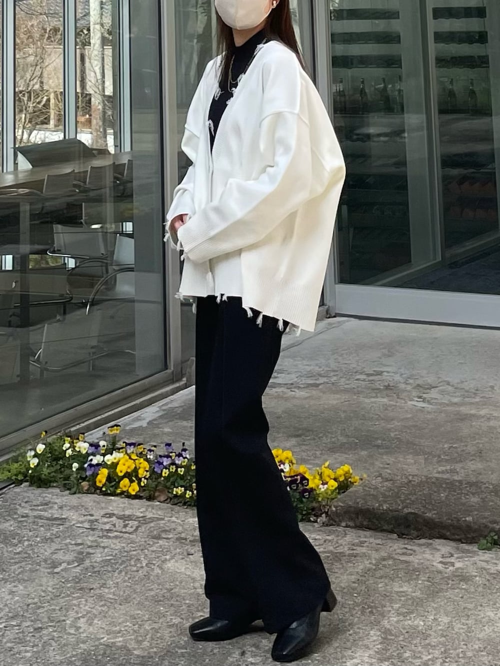 ホワイト系のジャケット/アウター、ブラック系のスラックス、ブラック系のブーツを着用したレディースの春コーディネートの2枚目の写真