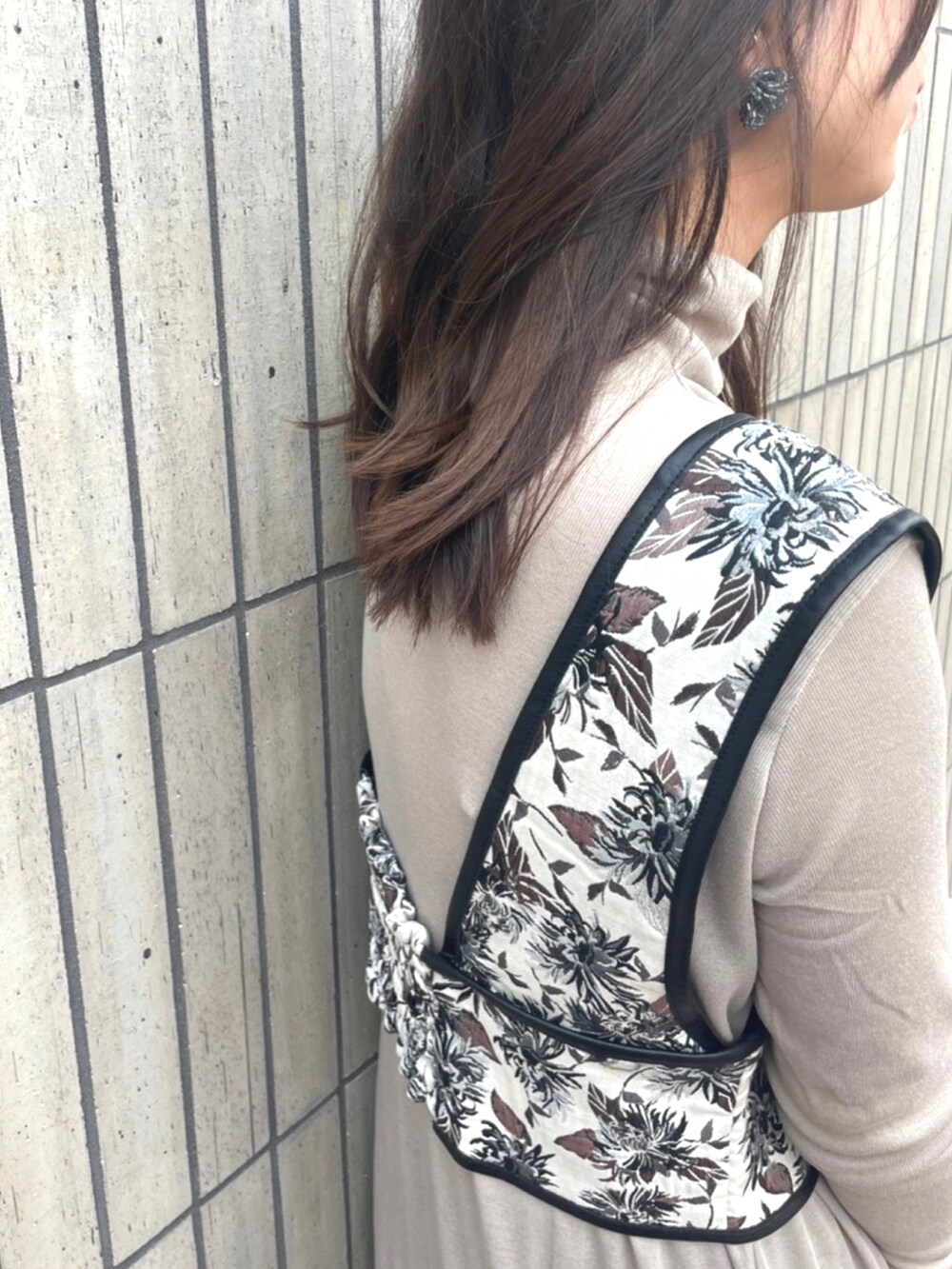 ブラック系のブーツ、ベージュ系のトップス、その他のベストを着用したレディースの秋コーディネートの3枚目の写真