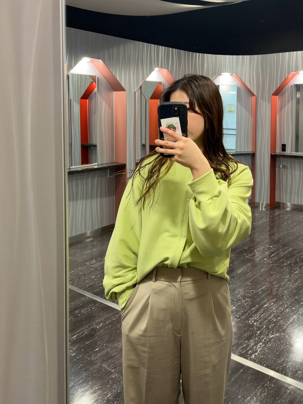 ベージュ系のパンツ、グリーン系のカーディガン/ボレロ、イエロー系のバッグを着用したレディースの春コーディネートの2枚目の写真