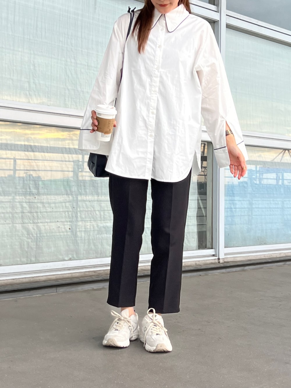 ホワイト系のシャツ/ブラウス、ブラック系のスラックス、ホワイト系のスニーカーを着用したレディースの夏コーディネートの2枚目の写真