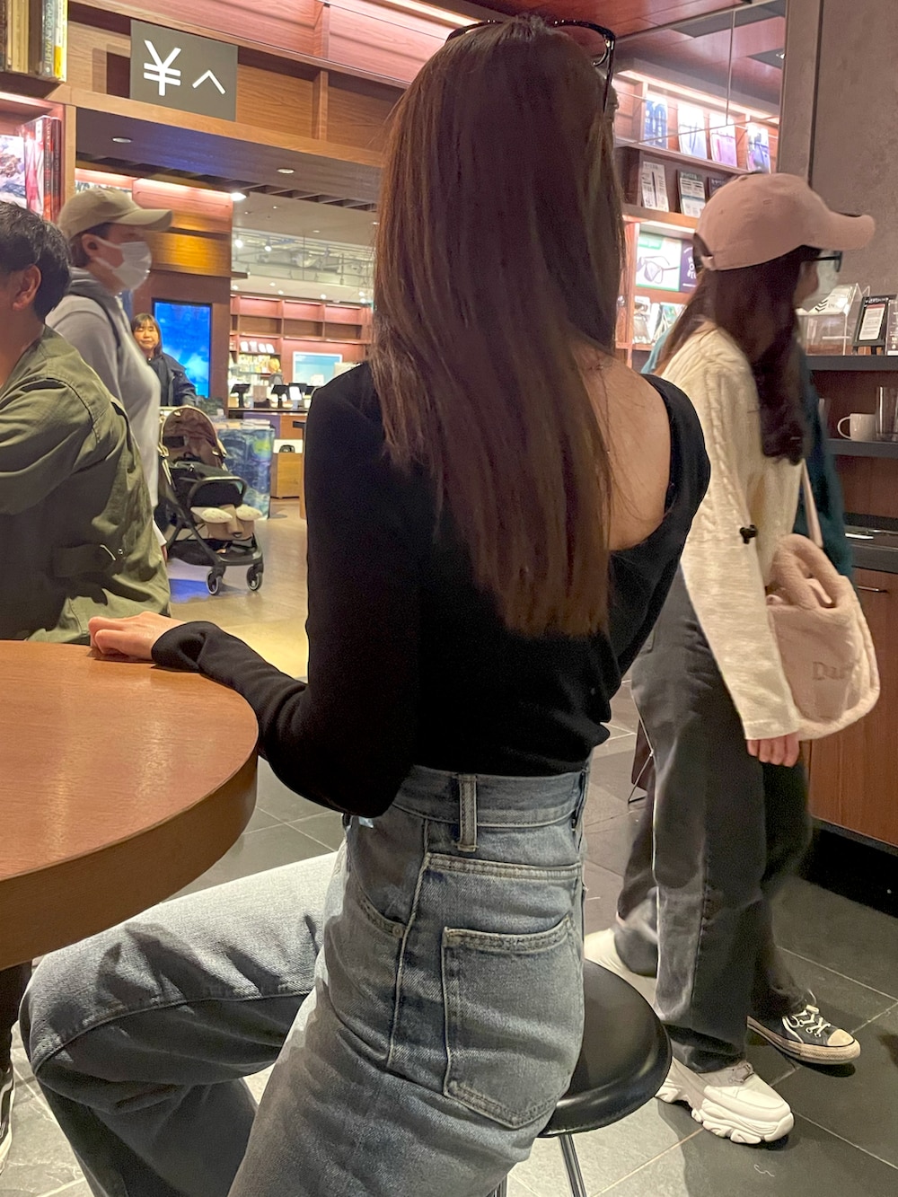 ブラック系のTシャツ/カットソー、ブルー系のデニムパンツを着用したレディースの春コーディネートの2枚目の写真