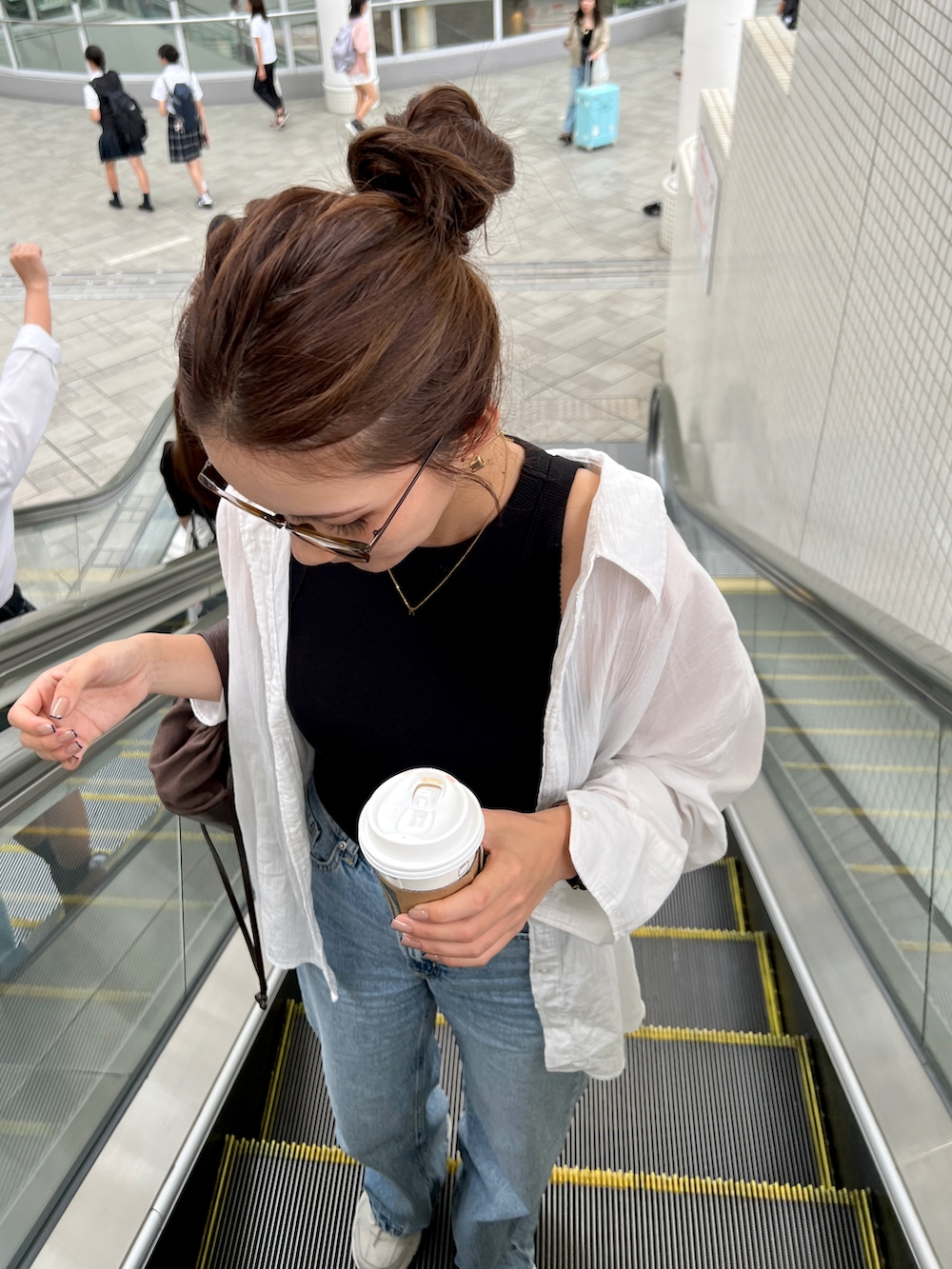 ブラック系のタンクトップ、ホワイト系のシャツ/ブラウス、ブルー系のデニムパンツを着用したレディースの秋コーディネートの2枚目の写真