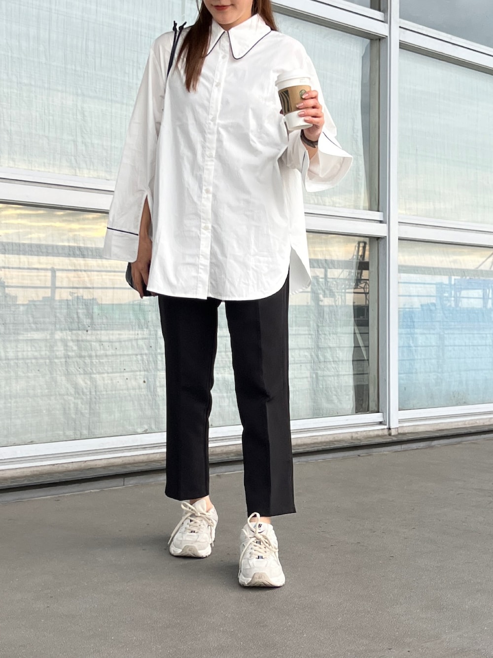 ホワイト系のシャツ/ブラウス、ブラック系のスラックス、ホワイト系のスニーカーを着用したレディースの夏コーディネートの3枚目の写真