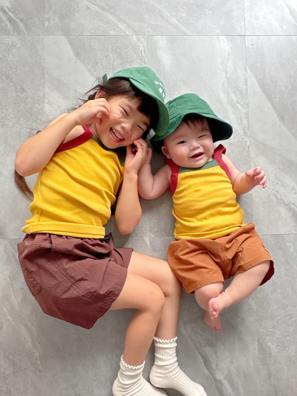 ブラウン系のその他パンツ、ブラウン系のその他パンツ、イエロー系のタンクトップを着用したキッズの夏コーディネートの3枚目の写真