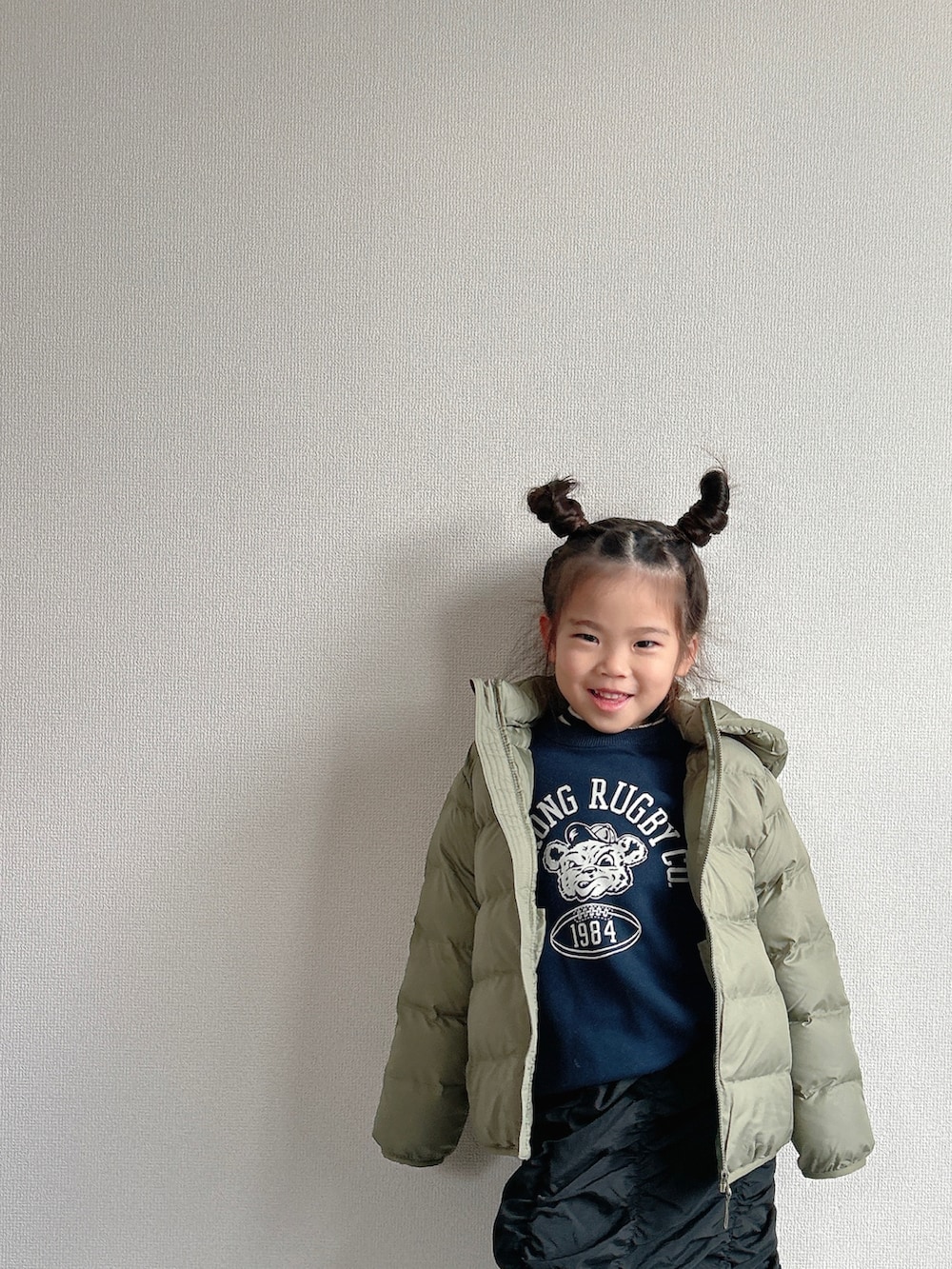 グリーン系のダウンジャケット/コート、ブルー系のスウェット、ブラック系のスカートを着用したキッズの冬コーディネートの2枚目の写真