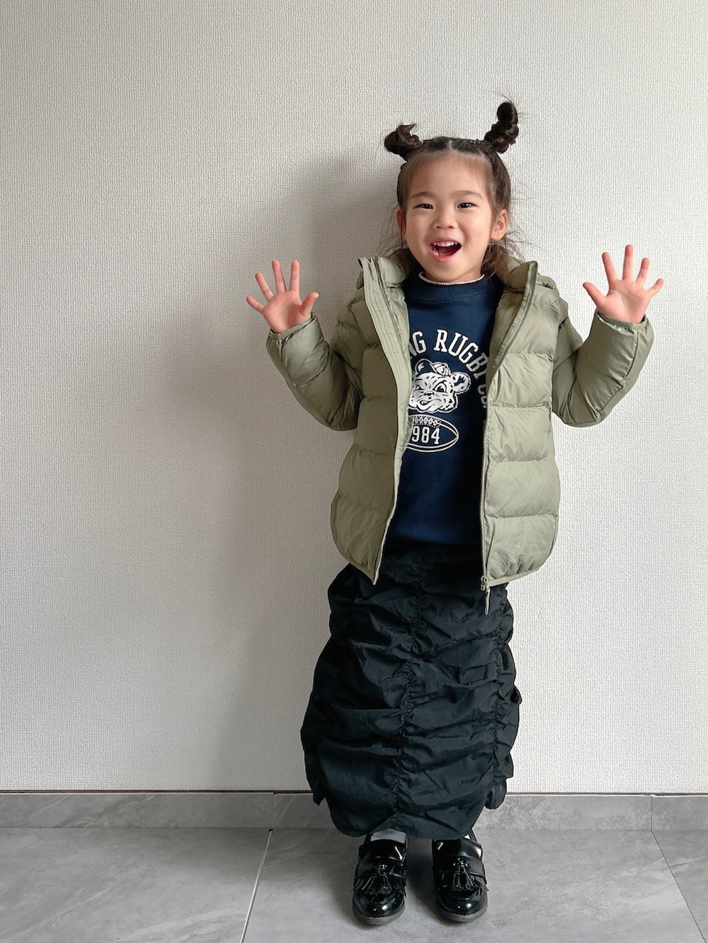 グリーン系のダウンジャケット/コート、ブルー系のスウェット、ブラック系のスカートを着用したキッズの冬コーディネートの3枚目の写真