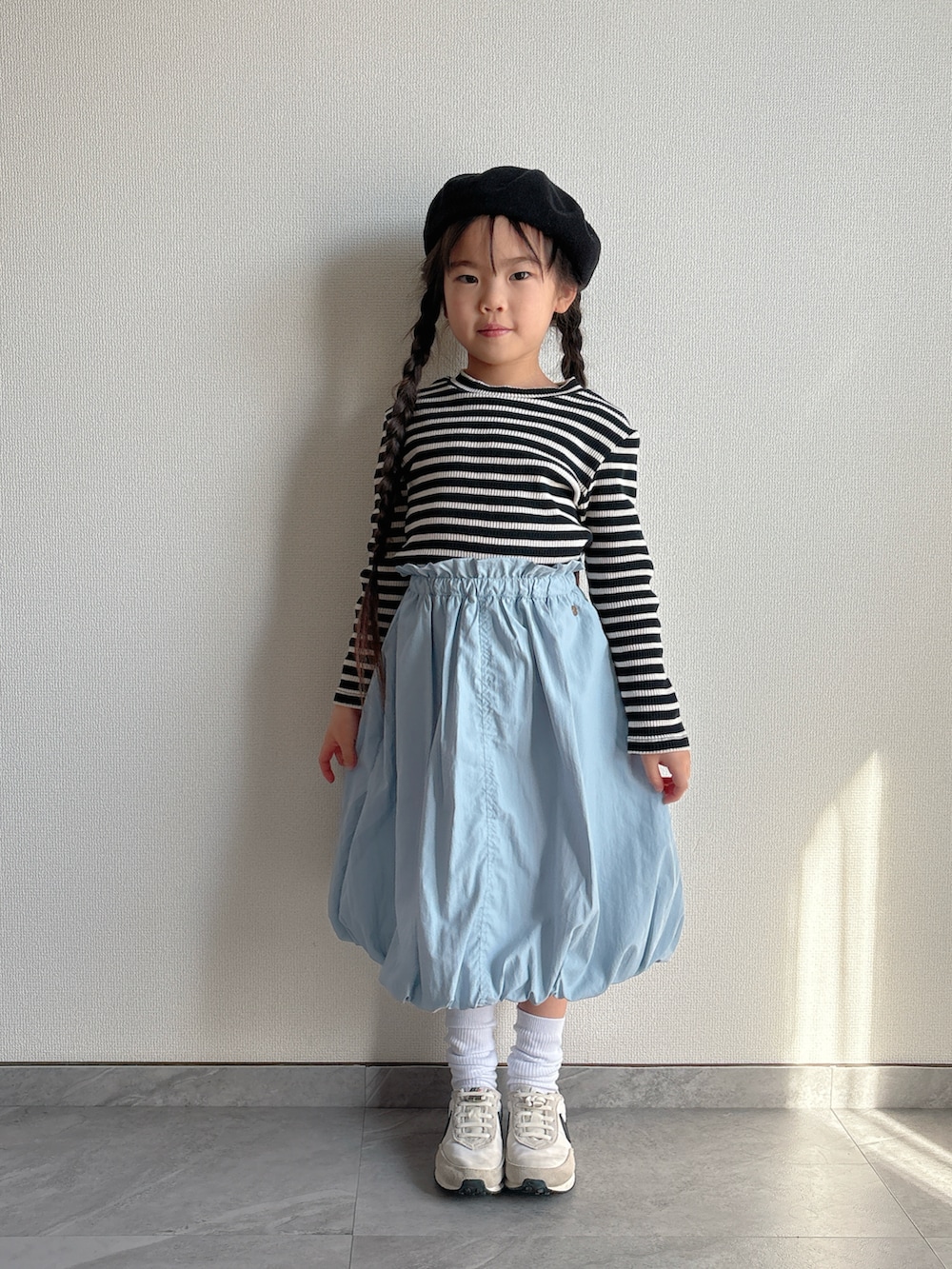 ブルー系のスカート、ホワイト系のスニーカーを着用したキッズの冬コーディネートの4枚目の写真