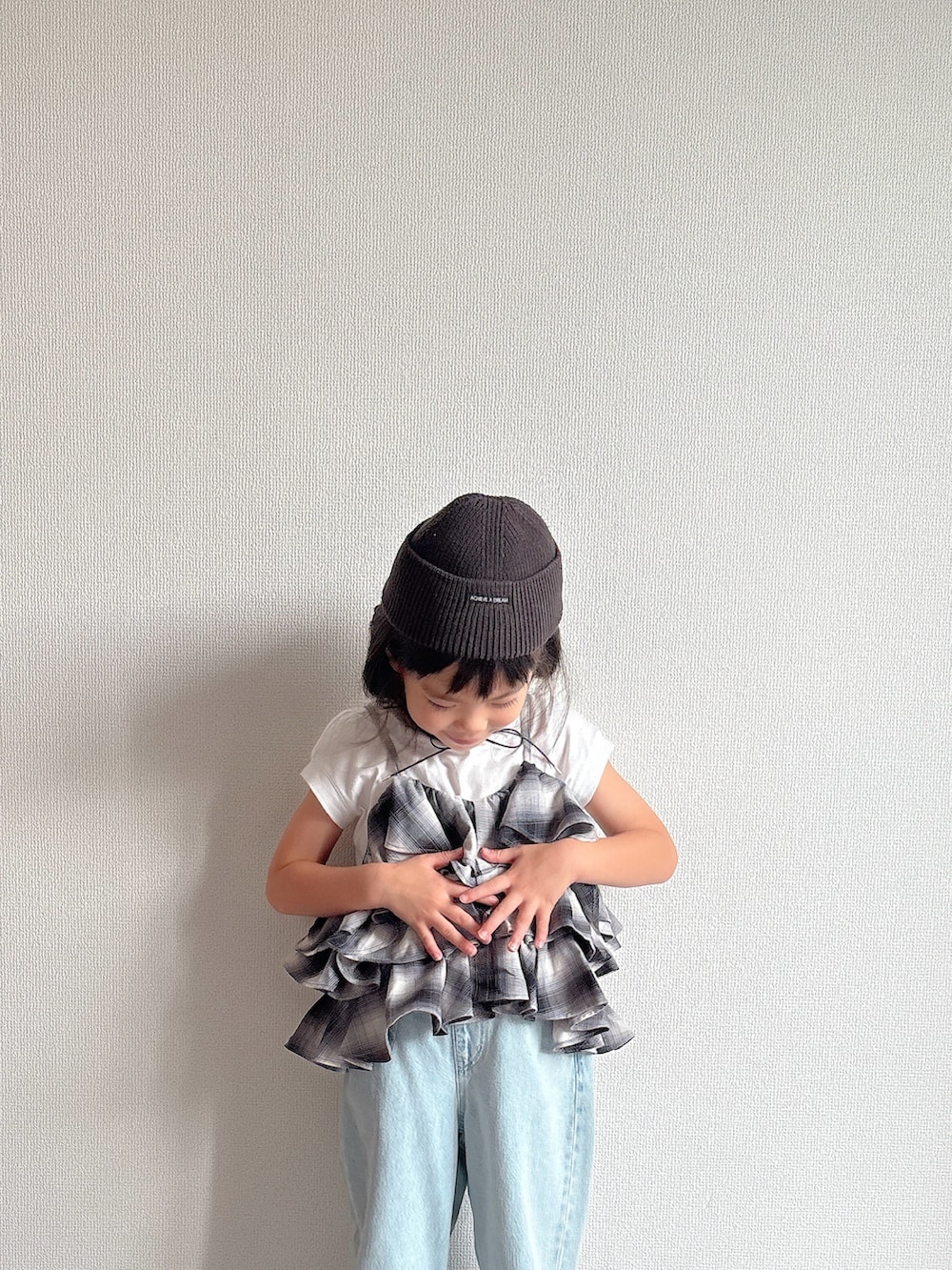 ブラック系のキャミソール、ブルー系のデニムパンツ、ブラック系のスニーカーを着用したキッズの夏コーディネートの5枚目の写真