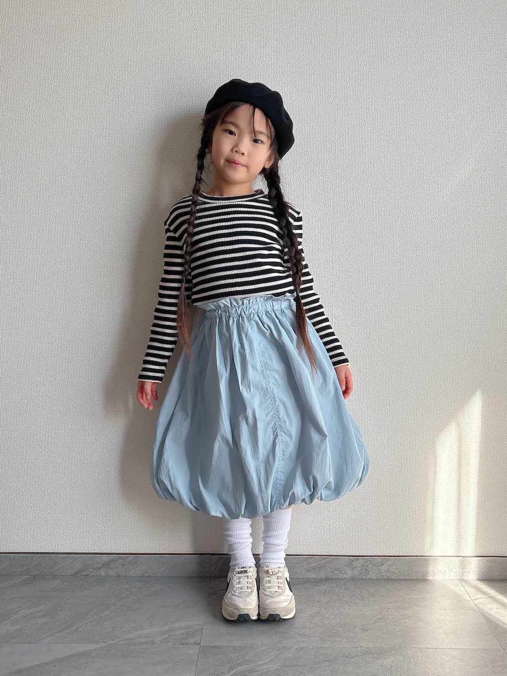 ブルー系のスカート、ホワイト系のスニーカーを着用したキッズの冬コーディネートの5枚目の写真