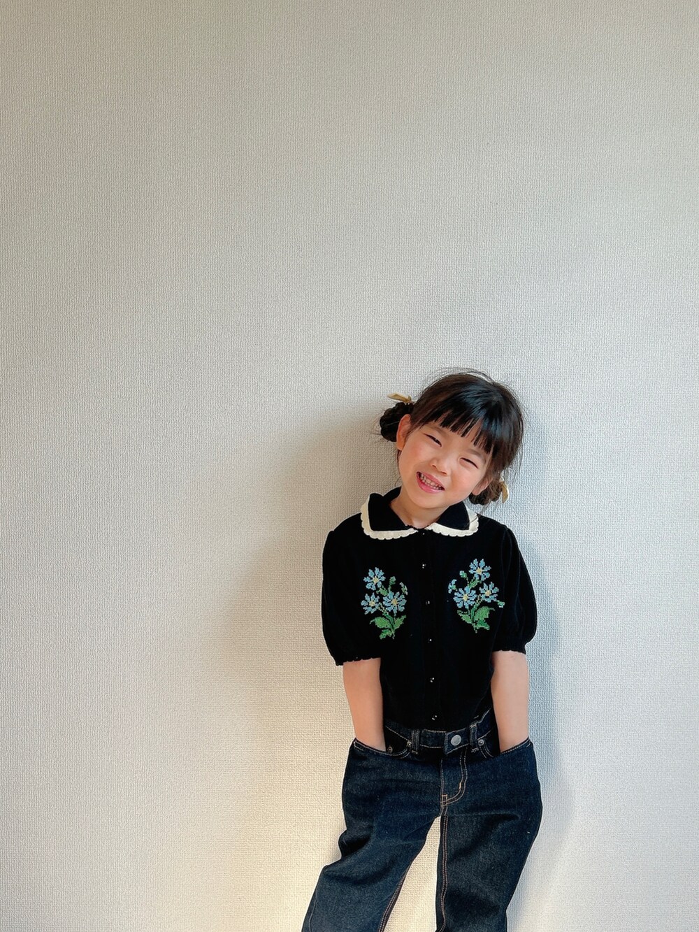 ブラック系のカーディガン/ボレロ、ブルー系のデニムパンツ、シルバー系のスニーカーを着用したキッズの春コーディネートの5枚目の写真