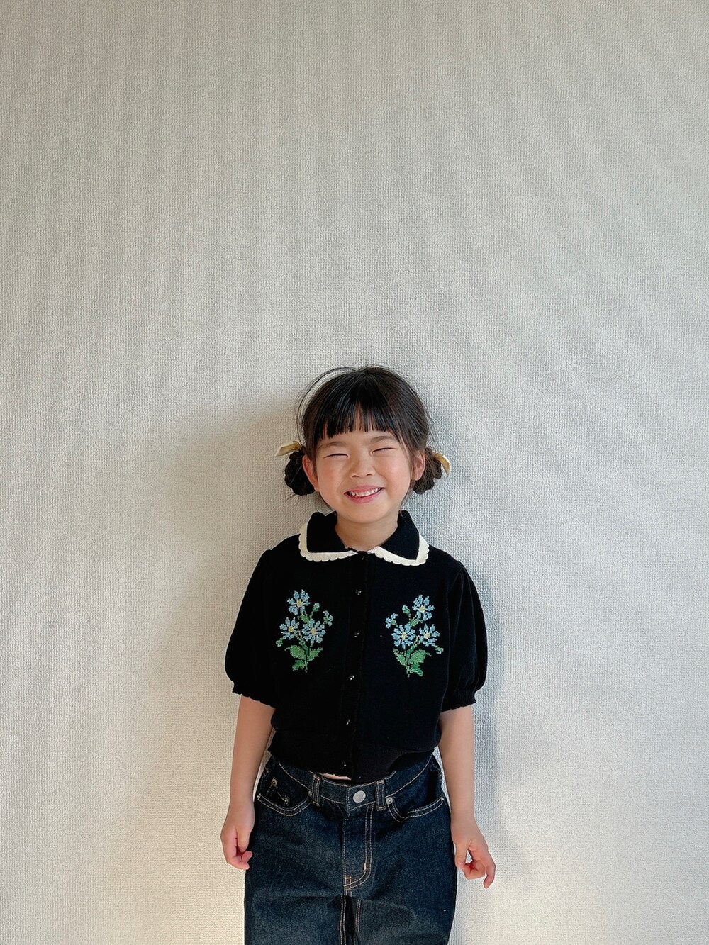 ブラック系のカーディガン/ボレロ、ブルー系のデニムパンツ、シルバー系のスニーカーを着用したキッズの春コーディネートの3枚目の写真