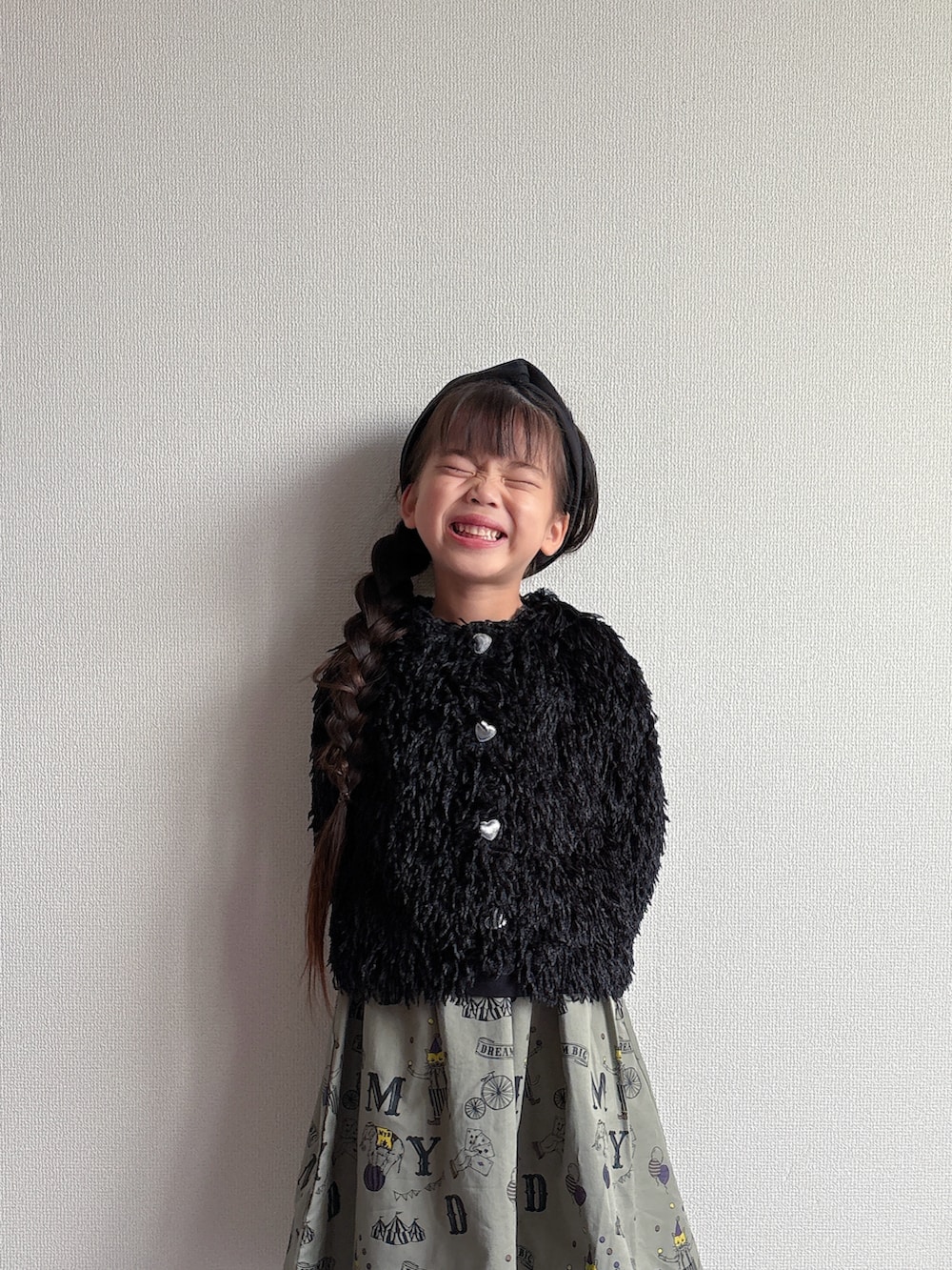 ブラック系のカーディガン/ボレロ、グリーン系のスカートを着用したキッズの秋コーディネートの4枚目の写真